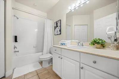 a white bathroom with a sink and a toilet and a tub at Townhome 4Q/3B perto da Disney -Lucaya Village in Kissimmee