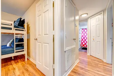 a room with two bunk beds and a hallway at Mickey's Cozy Condo Retreat in Kissimmee