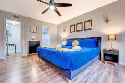 a bedroom with a blue bed and a ceiling fan at Mickey's Cozy Condo Retreat in Kissimmee