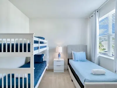 a bedroom with a bunk bed and a bed and a window at TR17226BD - 4 bedr w/pool - 10 guests Near Disney in Orlando