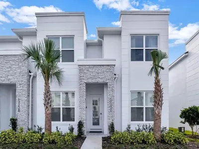 a white house with palm trees in front of it at TR17226BD - 4 bedr w/pool - 10 guests Near Disney in Orlando