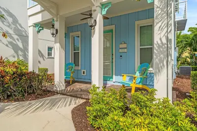 a blue house with two chairs on the front porch at Savannah Daydreamin - For 6 in Orlando