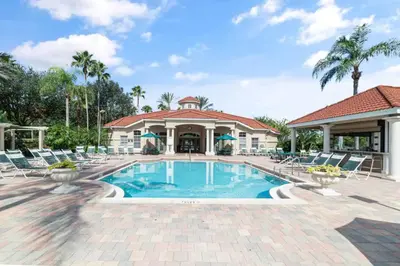 a swimming pool with chairs and a building at Magic Getaway at Emerald Island in Kissimmee