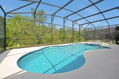 a large swimming pool in a building with a roof at 2616 TRANQUILITY KISSIMMEE 6 BED in Kissimmee
