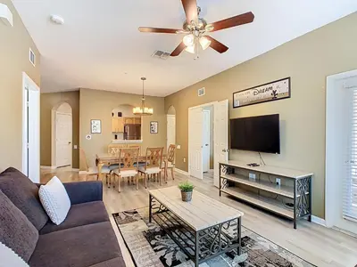 a living room with a couch and a flat screen tv at Windsor Hills 3BR - Mickey Themed Spacious Condo in Orlando