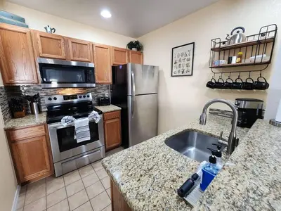 a kitchen with a stainless steel refrigerator and a sink at 3 Bedroom 2 Bathroom Villas At Seven Dwarfs 20-104 in Kissimmee
