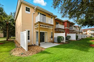 a large apartment building with a green yard at Resort stay Pool Access Peaceful Retreat Balcony in Kissimmee