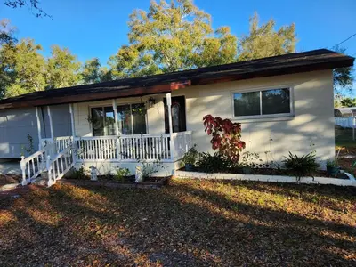 a small white house with a white porch at Sunny Retreat in Orlando