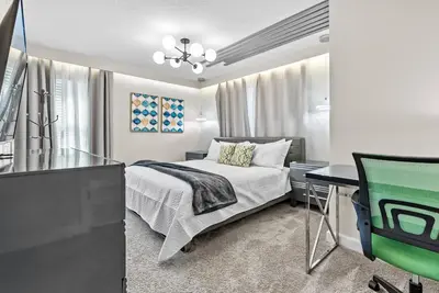 a bedroom with a bed and a desk and a television at Amazing 05 Bedrooms At Storey Lake in Kissimmee