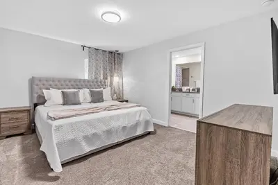 a white bedroom with a bed and a table at Amazing 05 Bedrooms At Storey Lake in Kissimmee
