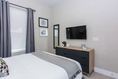 a bedroom with a bed and a flat screen tv at Magic 5bd House 8 min from Disney in Orlando