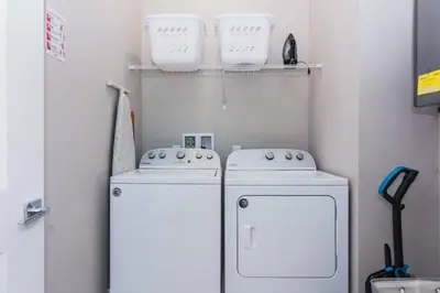 a laundry room with two washer and dryer at Magic 5bd House 8 min from Disney in Orlando
