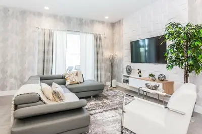 a living room with a couch and a tv at Magic 5bd House 8 min from Disney in Orlando