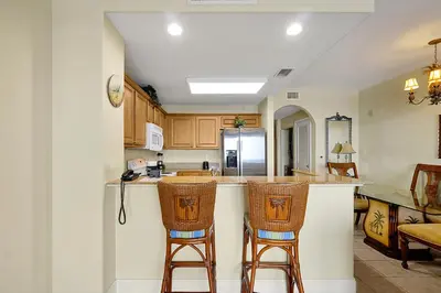 a kitchen with two bar stools and a counter at Disney Dream Condo & Lake View Awaits in Orlando