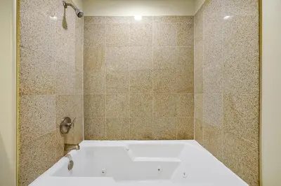a white bath tub in a tiled bathroom at Disney Dream Condo & Lake View Awaits in Orlando