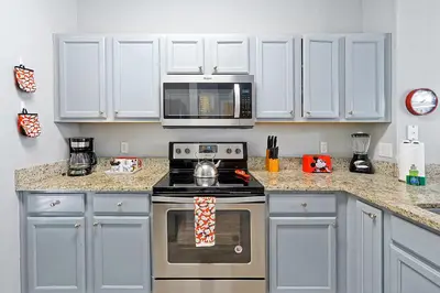a kitchen with a stove and a microwave at 8567 BAY LILY LOOP 3 BED in Kissimmee