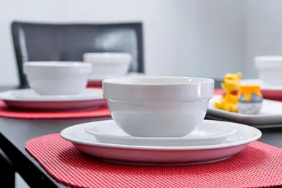a table with white bowls and plates on a red napkin at 8567 BAY LILY LOOP 3 BED in Kissimmee