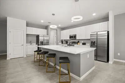 a kitchen with a large island with bar stools at 15 Bedrooms15 Bathrooms Veranda Palms 2393Sd in Kissimmee