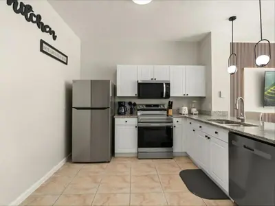 a kitchen with white cabinets and a stainless steel refrigerator at 3 Bedrooms 3 Bathrooms Windsor Palms 2318Sp in Kissimmee