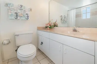a white bathroom with a toilet and a sink at 8702 PAPAYA DR 2BED in Kissimmee
