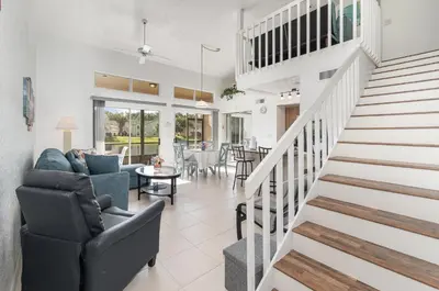 a living room with stairs leading to a dining room at 8702 PAPAYA DR 2BED in Kissimmee