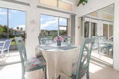 a table and chairs with a vase of flowers on it at 8702 PAPAYA DR 2BED in Kissimmee