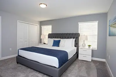 a bedroom with a large bed with blue and white sheets at Casa 4 Quartos c/ Piscina Privativa - Disney in Kissimmee