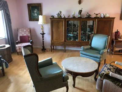a living room with chairs and a table and a cabinet at Family retreat with lake views and near Disney in Saint Cloud