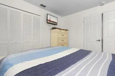 a bedroom with a bed and a tv on a dresser at 7742 WATER OAK KISSIMMIEE 4BED in Orlando