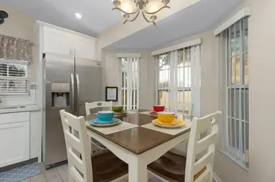a dining room with a table and chairs in a kitchen at 7742 WATER OAK KISSIMMIEE 4BED in Orlando