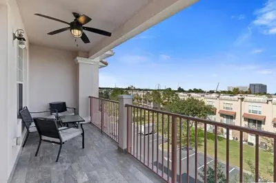 a balcony with a ceiling fan and a table and chairs at Amplo apê 4 quartos no Vista Cay Resort in Orlando