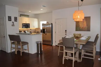 a kitchen and dining room with a table and a refrigerator at Charming 4-Bedroom Townhome in Lucaya Village Near Disney in Kissimmee