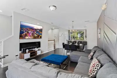 a living room with a couch and a tv at Moderno Triplex 3 Quartos no Vista Cay in Orlando