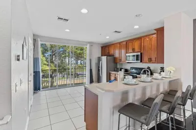 a kitchen with a large island with bar chairs at Moderno Triplex 3 Quartos no Vista Cay in Orlando