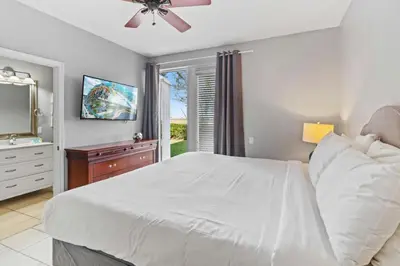 a bedroom with a white bed and a television at Apartamento 3 Quartos no Vista Cay perto da Disney in Orlando
