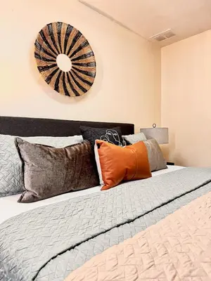 a bedroom with a large bed with orange and grey pillows at Modern 3BR Retreat with Comfort & Style Near Disney in Kissimmee