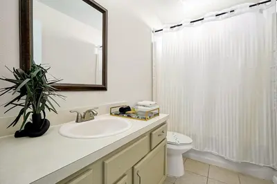 a bathroom with a sink and a toilet and a mirror at 938 Lake Berkley Kissimmee FL 34746 in Kissimmee