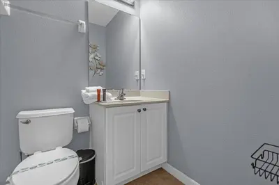 a bathroom with a toilet and a sink and a mirror at TVPM-1191MBBV in Kissimmee