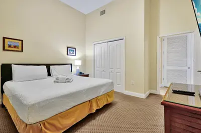 a bedroom with a large white bed and a desk at 13415 BLUE HERRON BEACH DR in Orlando
