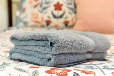 a pile of towels sitting on top of a bed at 13427 BLUE HERRON TOWER 1 UNIT 707 ORLANDO 1 BED in Orlando