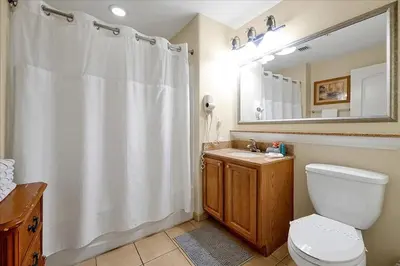 a bathroom with a white shower curtain and a toilet at 13427 BLUE HERRON TOWER 1 UNIT 707 ORLANDO 1 BED in Orlando