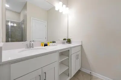 a white bathroom with a sink and a mirror at 3161 PARADOX CIRCLE UNIT 406 KISSIMMEE 2 BEDS in Kissimmee