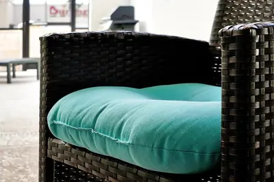 a wicker chair with a blue pillow on it at 5017 WINDERMERE 4BED in Kissimmee