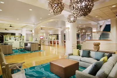 a lobby with couches and tables and a staircase at Wyndham Garden Lake Buena Vista – Disney Springs® Area in Orlando