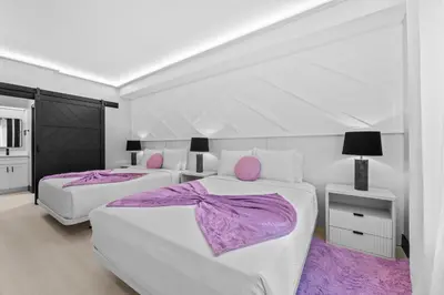 a white bedroom with two beds with purple blankets at Prime Location 1BR Apt Near Epic OCCC in Orlando