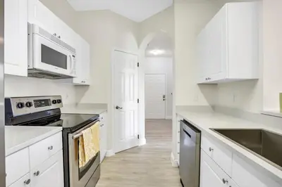 a kitchen with white cabinets and a stove top oven at Big Condo 3 bedrooms, Pool in Kissimmee