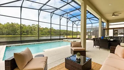 a living room with a pool and a glass house at Lakeside Villa with Pool BBQ Cinema & Games Room in Kissimmee
