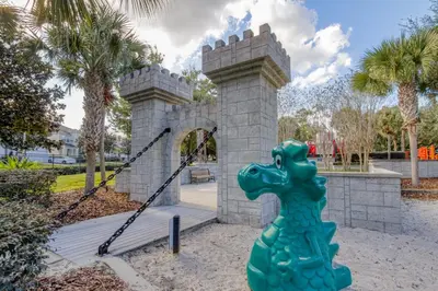 a green dinosaur statue in front of a castle at 7823 BEACHFIELD KISSIMME 4BED in Orlando