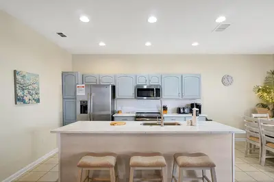 a kitchen with a large island with stools at 7823 BEACHFIELD KISSIMME 4BED in Orlando