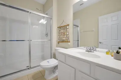 a bathroom with a toilet and a sink and a shower at 7823 BEACHFIELD KISSIMME 4BED in Orlando